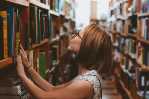 Femme cherchant un livre dans une bibliothèque
